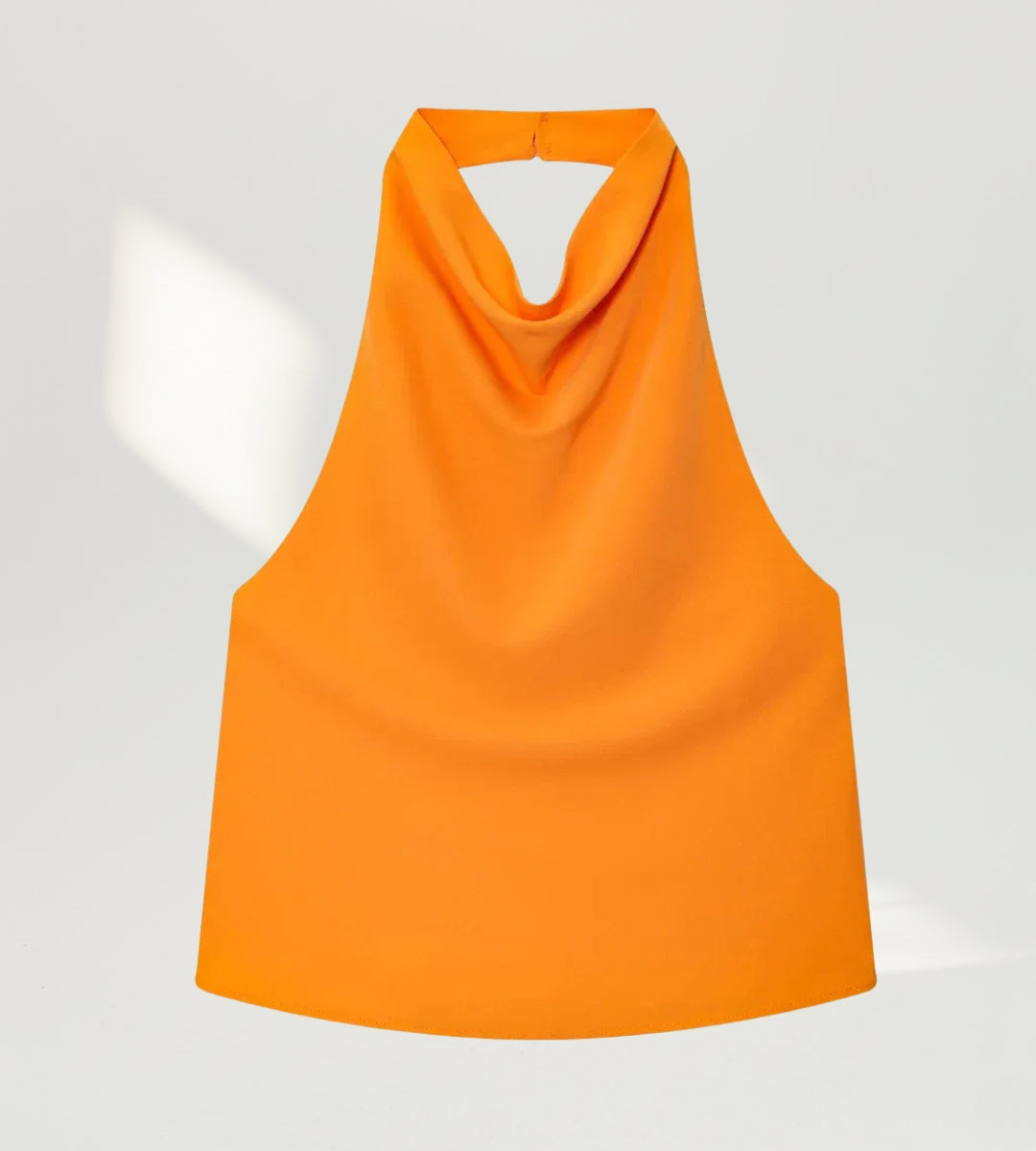 Detalhe do decote degagê drapeado no busto do top laranja exclusivo da Saybeleze.