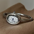 Relógio oval elegante feminino com mostrador branco e ponteiros azuis