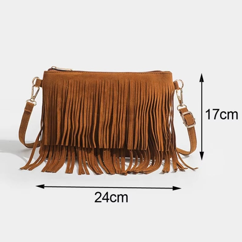 Detalhe da alça ajustável com fivela dourada da bolsa de franjas marrom em suede.