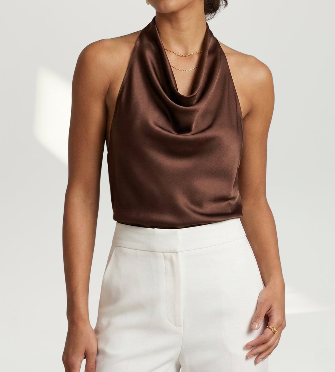 Look sofisticado com blusa marrom Verona e acessórios dourados para evento noturno.