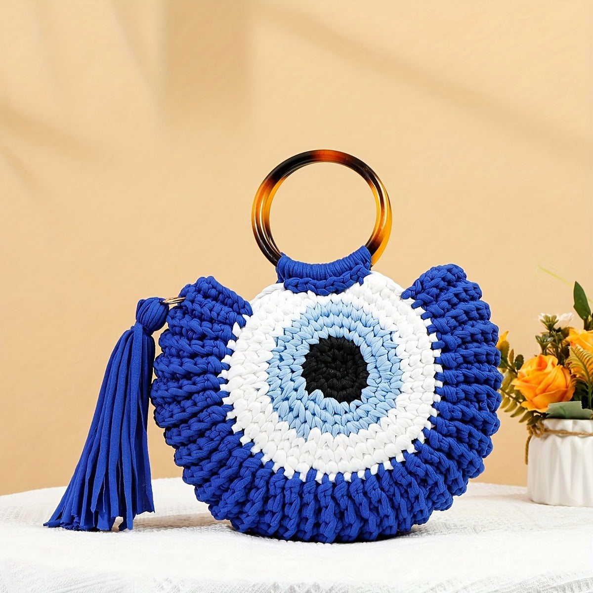 Bolsa feminina crochê azul com design olho grego artesanal e argolas rígidas
