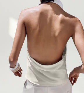 Look feminino de festa com blusa de cetim branca para a moda 2026 em cenário sofisticado.