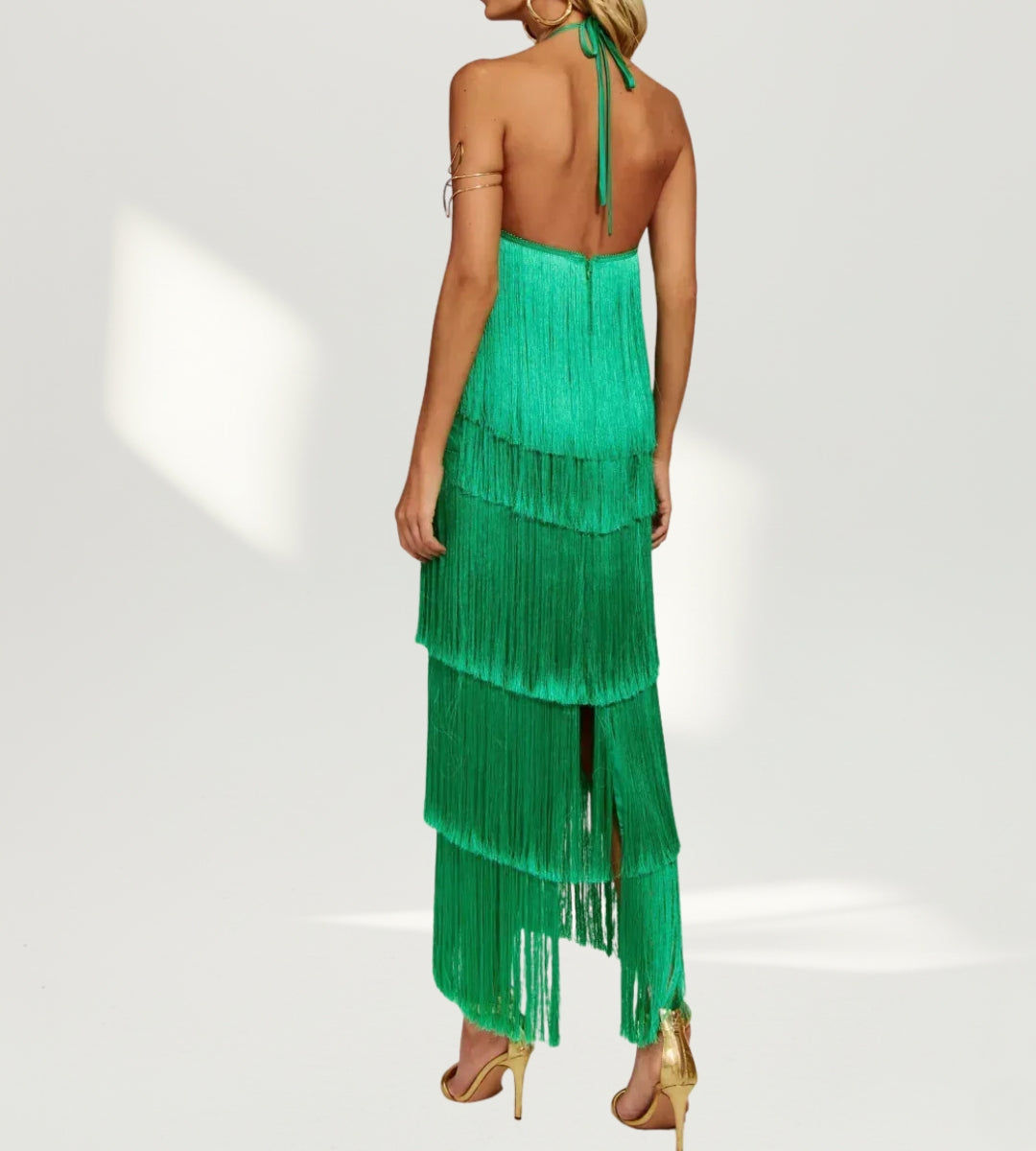 Vista lateral do vestido longo verde esmeralda realçando a fluidez da modelagem sheath.