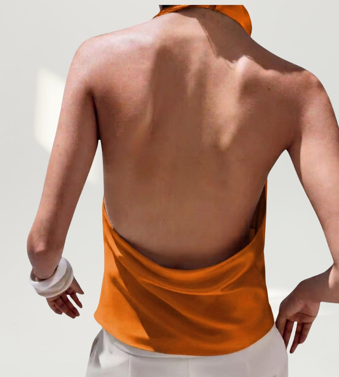 Vista de costas da blusa frente única aberta nas costas na cor laranja solar.