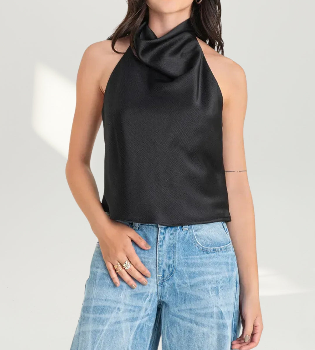 Mulher posando com a blusa preta Capri para a Moda feminina festa 2026.