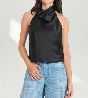 Mulher posando com a blusa preta Capri para a Moda feminina festa 2026.