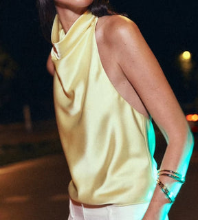 Vista lateral da blusa amarela destacando o caimento do tecido.