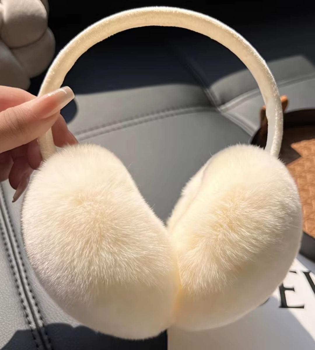 protetor de orelha feminino na cor bege com acabamento em pelúcia macia, ideal para proteção contra frio com conforto e estilo elegante