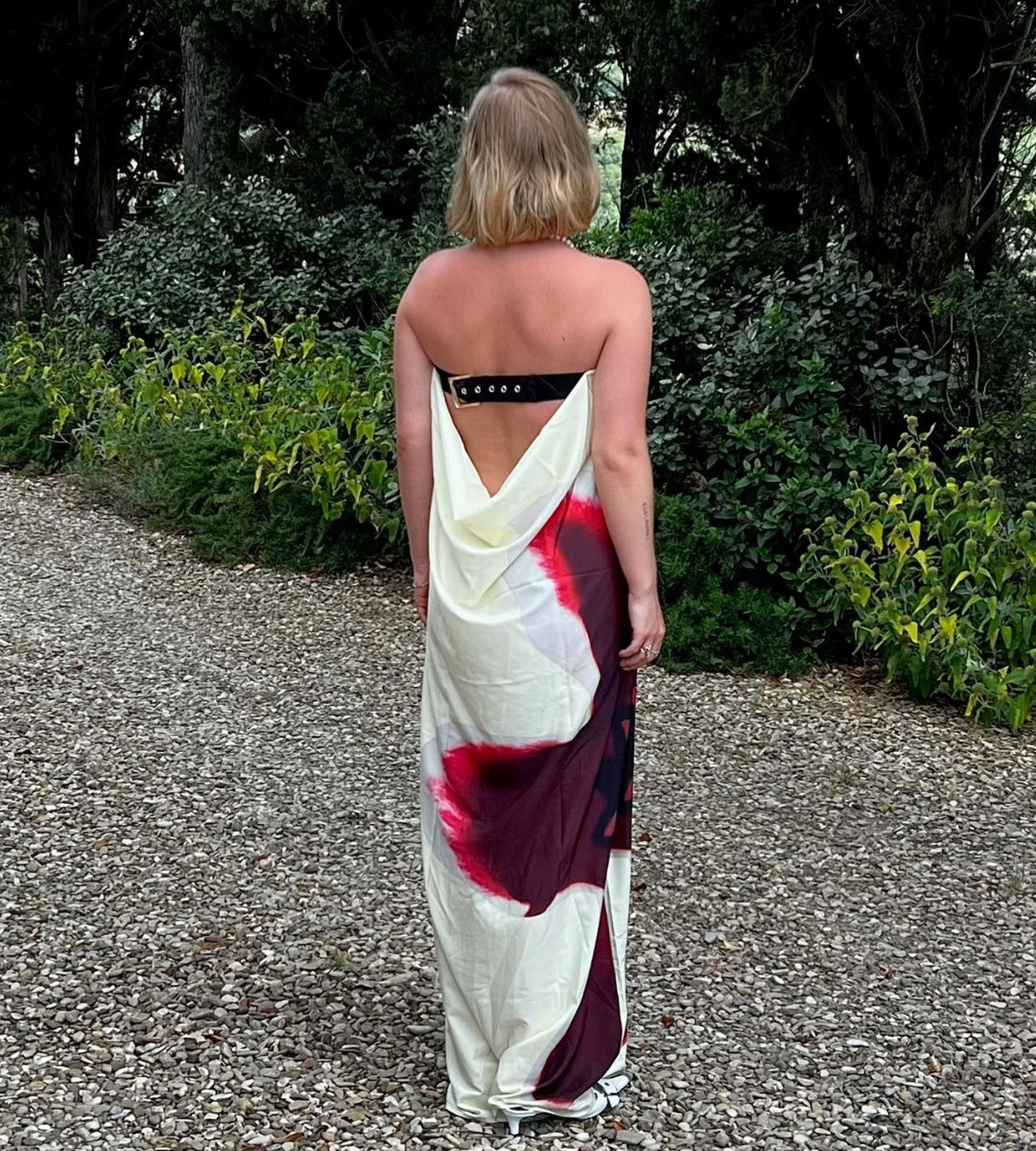 Mulher caminhando com vestido longo floral realçando o movimento leve do tecido tecnológico.