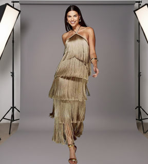 Mulher posando com vestido longo castanho em camadas de franjas de frente com acabamento acetinado de luxo.