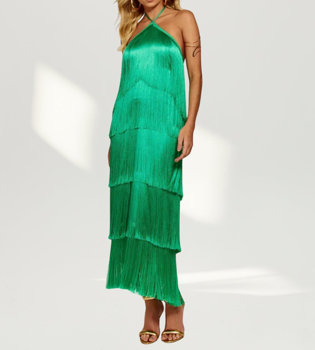 Modelo de costas exibindo o decote profundo e as franjas verdes em camadas do vestido Saint-Barth.