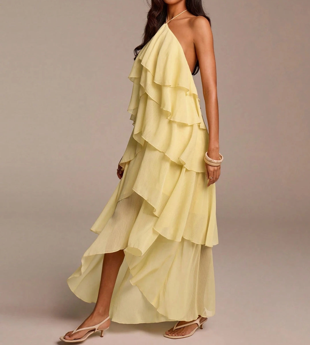 O Vestido Aurora posicionado de lado, destacando a fluidez e o volume estratégico das camadas.